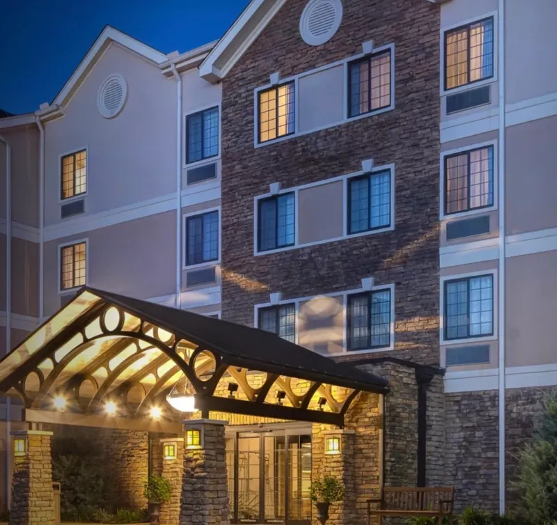 The covered entrance of Staybridge Suites Tallahassee at dusk, its windows lit.