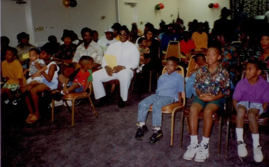A hall full of family seated in rows.