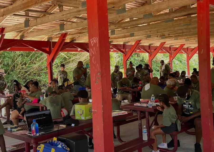 A full red picnic pavilion, tables crowded with family.