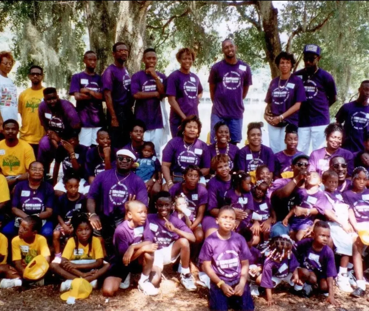 Rows of relatives in purple reunion T-shirts beneath moss-hung oaks.